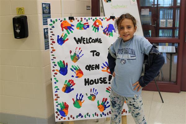  Student in front of Welcome to Open House sign