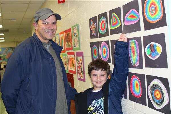  Student showing their artwork to parent