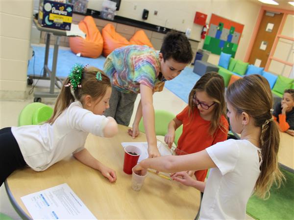  students working at table together 