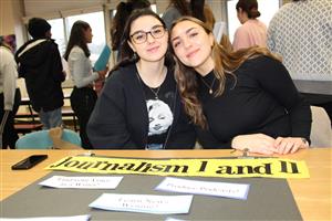 2 girls pose with Journalism sign 