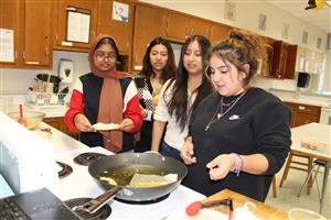 girls frying food in kitchen 