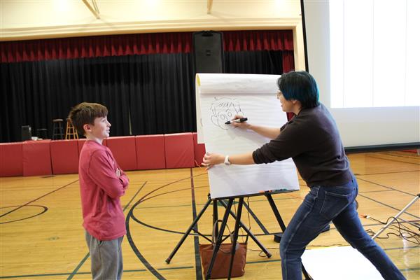   Gale Galligan drawing a cartoon of a middle school student