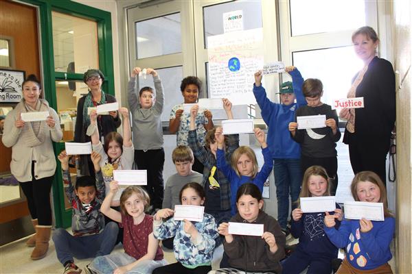 students holding up pieces of paper with quotes 