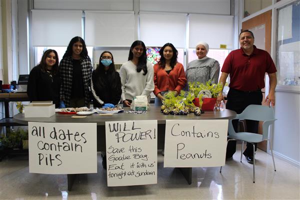  students standing at desk with food 