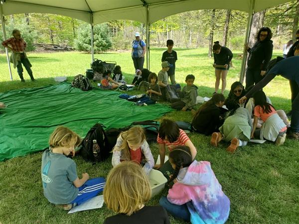  kids studying together under tent 