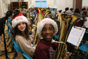   students holding baritone horns wearing santa hats