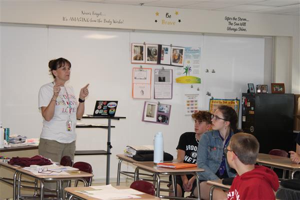  teacher teaching in front of classroom 