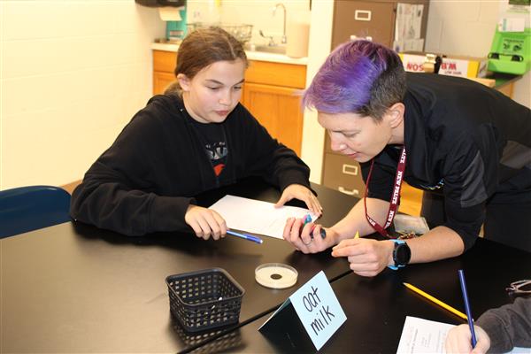  Teacher and student working together in science class