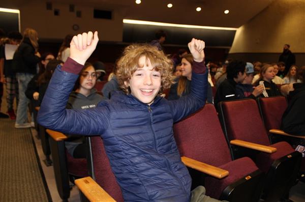  student with arms raised in excitement