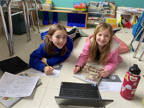 girls doing project on floor 