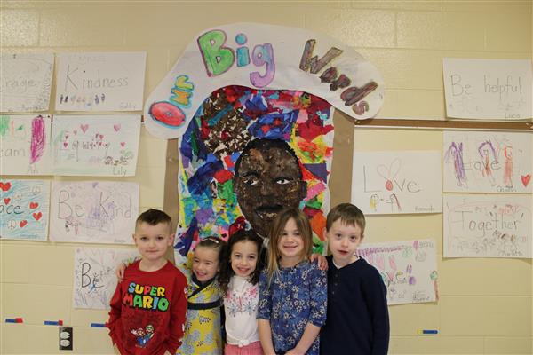  Students posing in front of their hallway mural