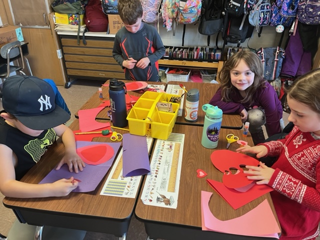  students making valentines day cards 