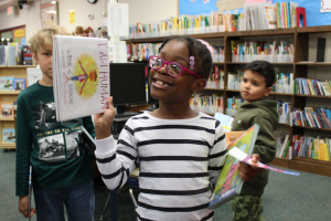   student posing with books in the library