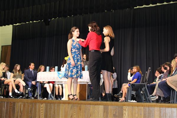  girl getting pinned on stage in ceremony 