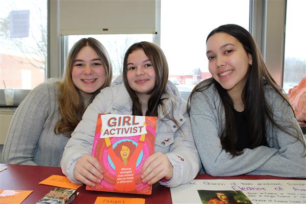  Three students posting with "Girl Activist" book.