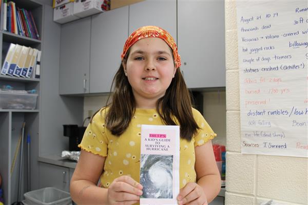  Student holding her project - a brochure entitled, "A Kids Guide to Surviving a Hurricane."